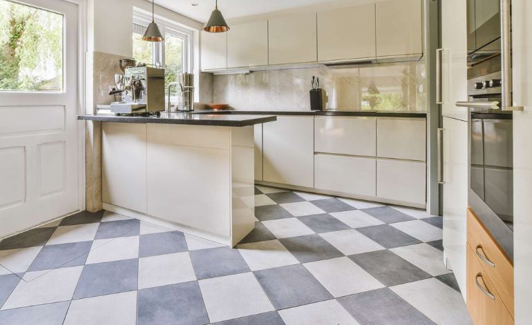 A stylish kitchen with a checkered floor and white cabinets, representing tile flooring services in Sacramento, CA.